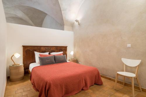 - une chambre avec un lit et une couverture rouge dans l'établissement Honorê - Suite Romain Rolland, à Lyon