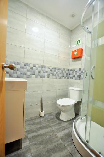 a bathroom with a toilet and a sink and a shower at Suites & Apartments - DP Setubal in Setúbal