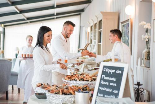 a group of people standing around a buffet of food at Grand Hôtel Les Flamants Roses Thalasso & Spa in Canet-en-Roussillon