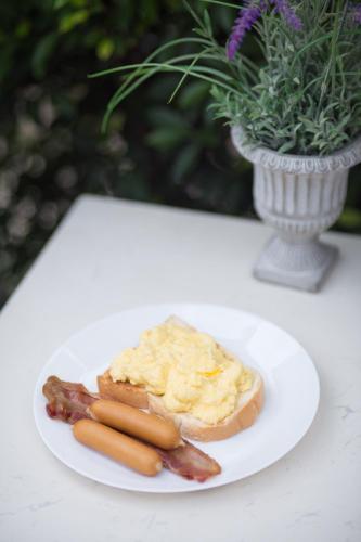 a plate of food with bacon and eggs on a table at The Rodman Hotel in Chiang Mai