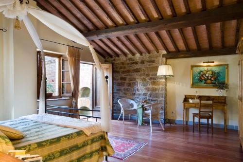a bedroom with a bed and a desk in a room at Tenuta Sant'Ilario in Gambassi Terme