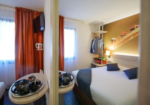 um quarto de hotel com duas camas e uma janela em Hotel Inn Design Resto Novo Challans em Challans