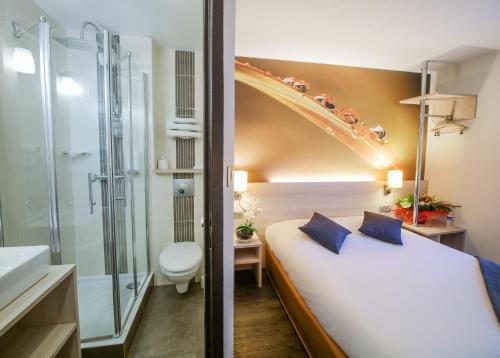 um quarto de hotel com uma cama e um chuveiro em Hotel Inn Design Resto Novo Challans em Challans