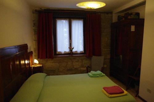 a bedroom with a green bed and a window at Fattoria La Guedrara in Sestola