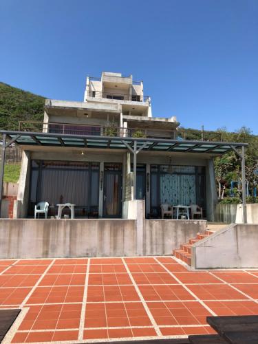 a house with a patio and a red brick floor at Beach Shoes Villa in Yanliau