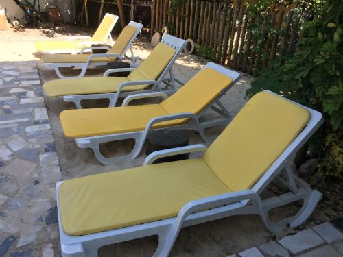 a row of yellow chairs sitting on a patio at Ria Studios in Olhão