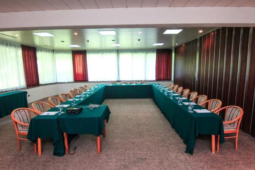 a conference room with green tables and chairs at Hotel Grand in Sarajevo