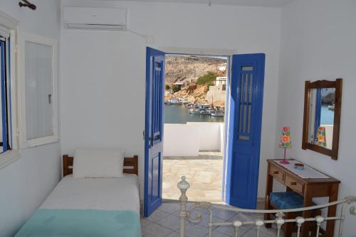 CherronisosにあるAmmos Holiday Houseの青いドアが付いたベッドルーム1室が備わり、港の景色を望めます。
