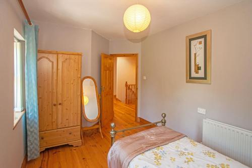 a bedroom with a bed and a mirror in it at Cottage 182 – Letterfrack in Letterfrack