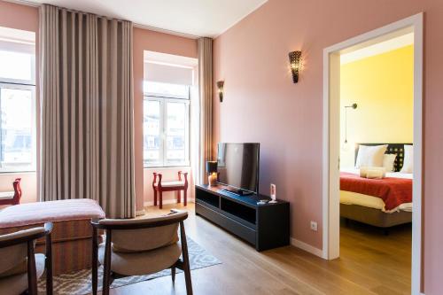 a hotel room with a bed and a television at ALTIDO Sublime 2BR Apt on Restauradores Square nearby Rossio Station in Lisbon