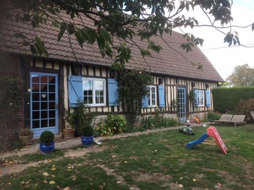 une maison avec une aire de jeux dans la cour dans l'établissement Chambre meublée 