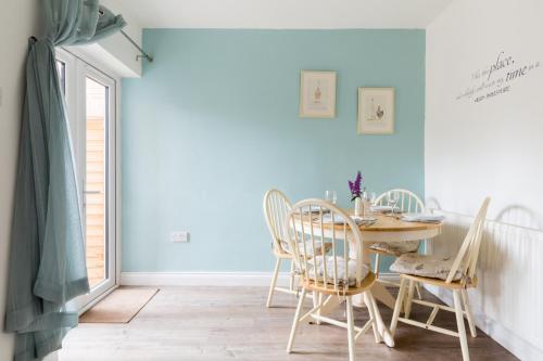 a dining room with blue walls and a table and chairs at Baker's Dozen in Stratford-upon-Avon