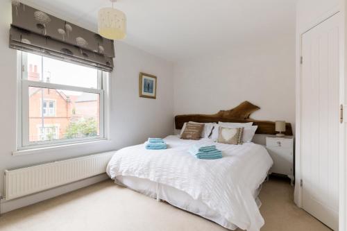 a white bedroom with a bed and a window at Baker's Dozen in Stratford-upon-Avon