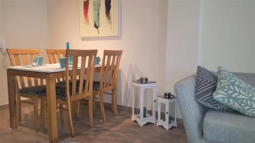 a dining room table with chairs and a couch at URBANA SUITES & STUDIOS 440 in San Carlos de Bariloche