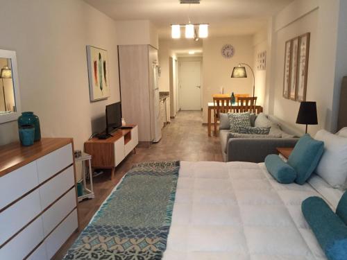 - un salon avec un grand lit et un canapé dans l'établissement URBANA SUITES & STUDIOS 440, à San Carlos de Bariloche