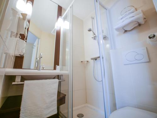 a bathroom with a shower and a toilet at Hôtel Inn Design Resto Novo Alençon in Alençon