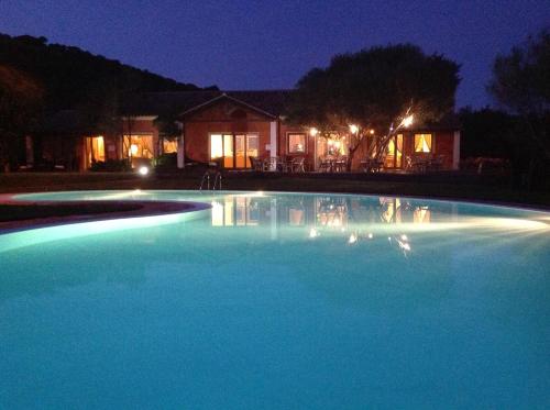 a large blue swimming pool at night at Hotel Aldiola Country Resort in Sant Antonio Di Gallura