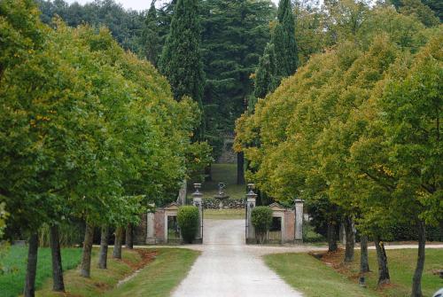 einen Weg durch einen Park mit Bäumen und einem Friedhof in der Unterkunft Agriturismo Poggiolo in Pilonico Materno
