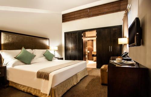 a hotel room with a large bed and a desk at Avani Lesotho Hotel & Casino in Maseru