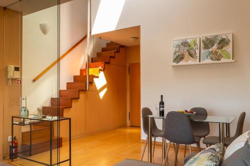 a living room with a staircase and a table and chairs at Portus Vita Apartamento T0 Duplex in Vila Nova de Gaia