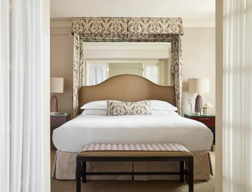 a bedroom with a large bed with a large headboard at The Eliot Hotel in Boston