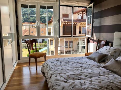 una camera con un letto in una stanza con ampie finestre di Chalet en Espinosa Monteros a Espinosa de los Monteros
