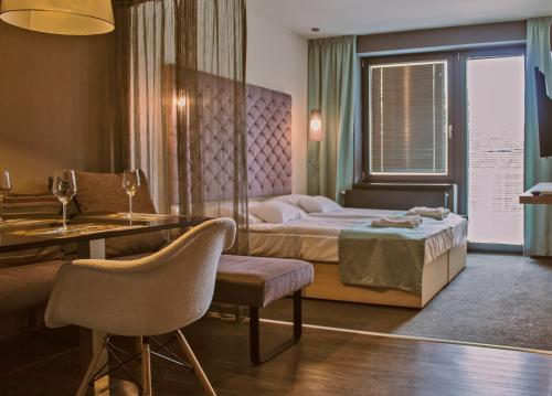 Habitación de hotel con cama, mesa y sillas en Orion Apartman, en Sárvár