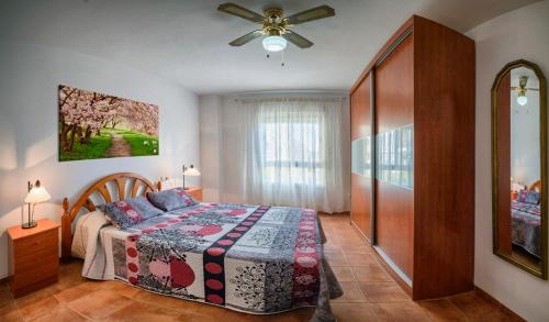 een slaapkamer met een bed en een plafondventilator bij Apartamento 90 m2 en la mejor zona de Roquetas in Roquetas de Mar