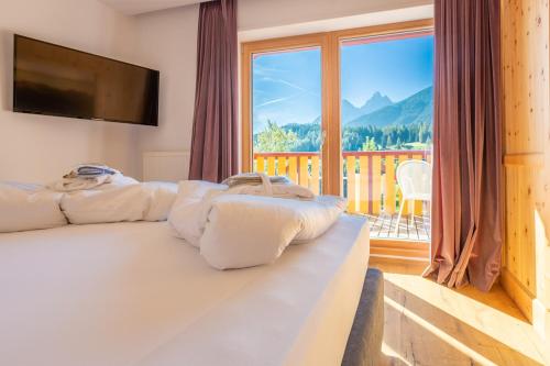a bedroom with a bed with a large window at Hotel Villa Stefania in San Candido