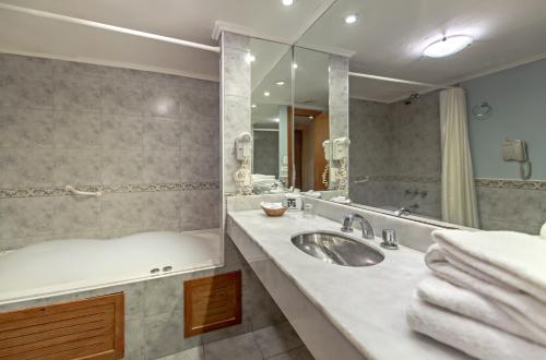 
a bathroom with a sink, toilet and bathtub at Hotel Tronador in Mar del Plata
