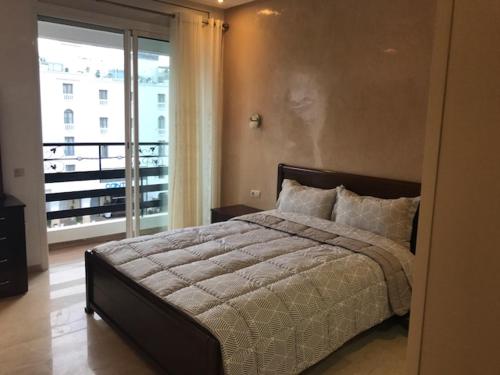 a bedroom with a large bed and a balcony at Le nid du centre ville in Rabat
