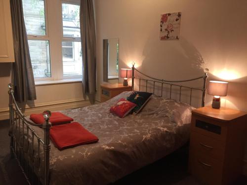 a bedroom with a bed with two red towels on it at Apartment close to Pavilion gardens in Buxton