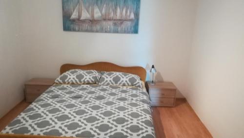 a bedroom with a bed and a painting on the wall at Apartment Stinica 26 E in Jablanac