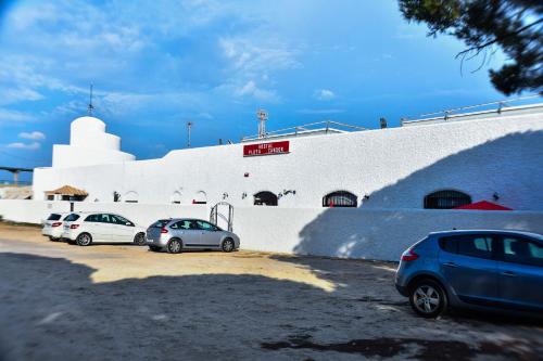 three cars parked in a parking lot in front of a building at Hostal Playa Candor in Rota