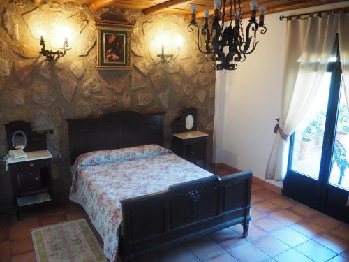 a bedroom with a bed and a stone wall at Hotel Rural El Convento in Valencia de Alcántara