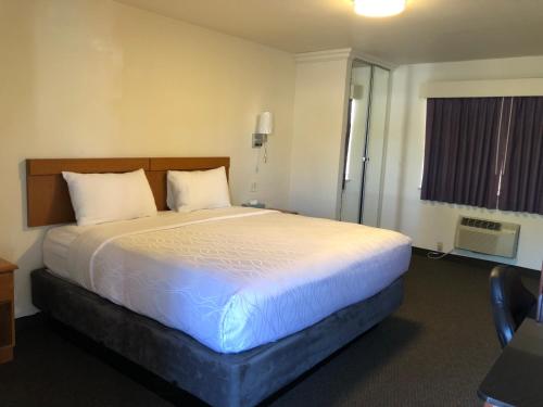 a bedroom with a large bed in a hotel room at Monticello Motel in Portland
