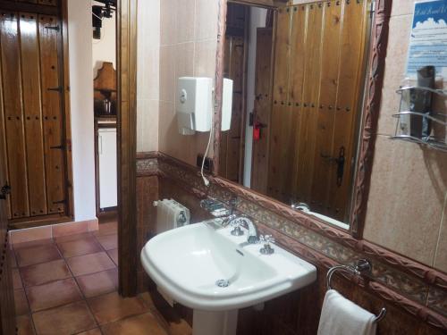 W łazience znajduje się umywalka i lustro. w obiekcie Hotel Rural El Convento w mieście Valencia de Alcántara
