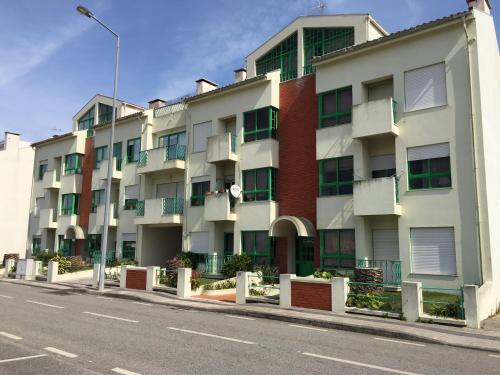 an apartment building on the side of a street at Verde Ria apartamento in Torreira