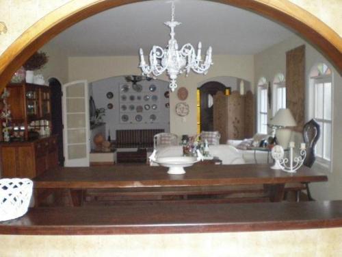 a living room with a chandelier and a table at Casa De Campo Boituva in Boituva