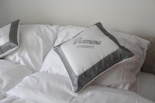 a white couch with a pillow with the word pendulum involuntary at Panorama Apartments in Karlovy Vary