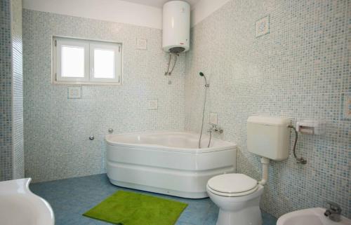 Un baño con bañera, inodoro y lavabo. en Holiday Home Koprivno, en Koprivno