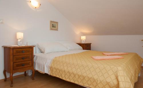 Un dormitorio con una cama y una mesita de noche con dos toallas encima. en Holiday Home Koprivno, en Koprivno