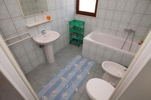 a bathroom with a toilet and a sink and a tub at Apartments Irena in Trogir