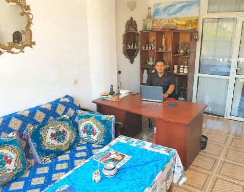 a man is sitting at a desk with a laptop at Maison de la Lagune in Oualidia