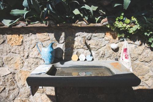 a statue of a blue vase sitting on a stone wall at Exclusive beautiful pool house surrounded by greenery, modern, luxury finishes in Camaiore