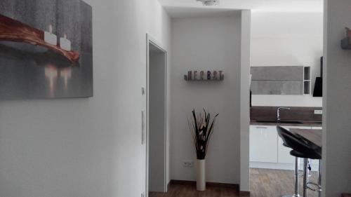 uma cozinha com paredes brancas e um vaso com paus em Im Hirzenbruch 1 em Nohfelden