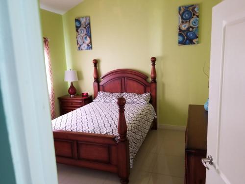a bedroom with a wooden bed in a room at Caymanas estate beautiful two bedroom suites in Goshen Pen