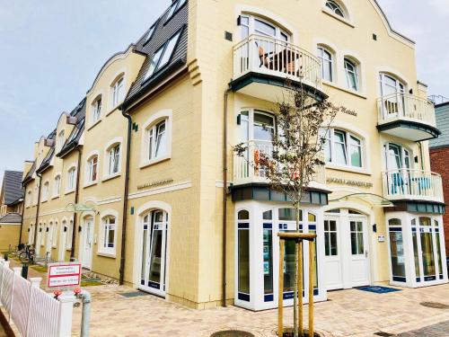 a large yellow building with a balcony on it at Ankerplatz-Sylt @Haus Mateika in Westerland (Sylt)
