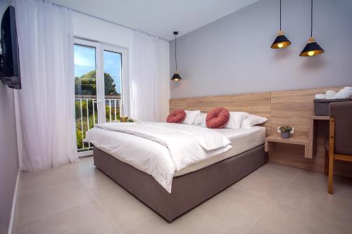 a bedroom with a bed and a large window at Villa Filip in Kaštela