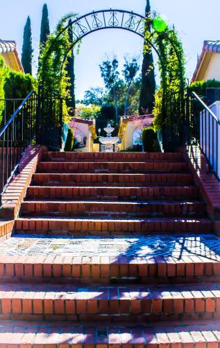 a set of stairs with an arch and a fountain at Los Gatos Garden Inn Hotel in Los Gatos